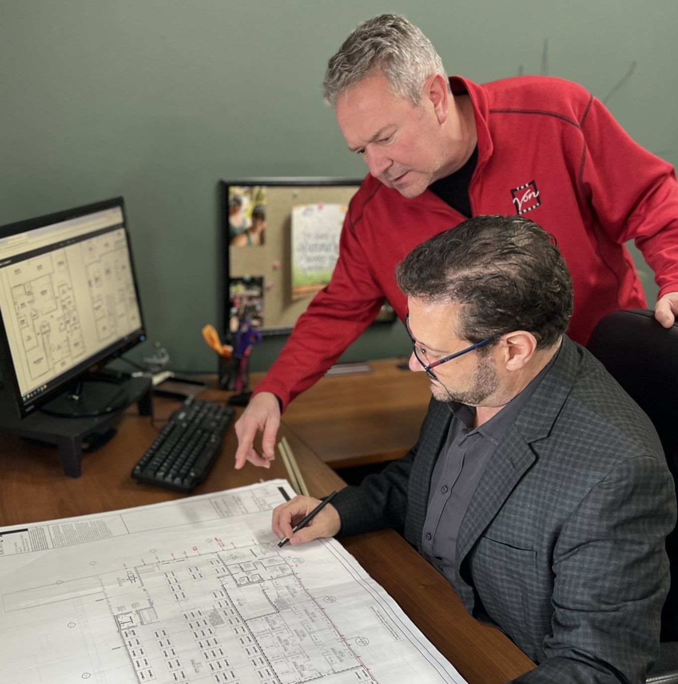 Two team members reviewing architectural drawings together